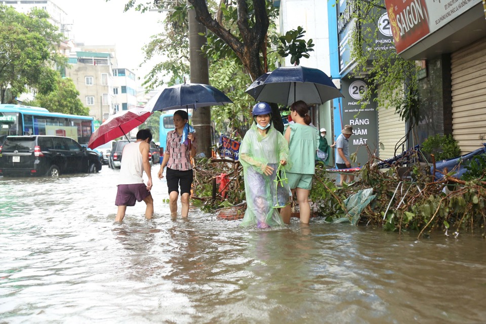 Người đi bộ lội nước tr&ecirc;n vỉa h&egrave;.