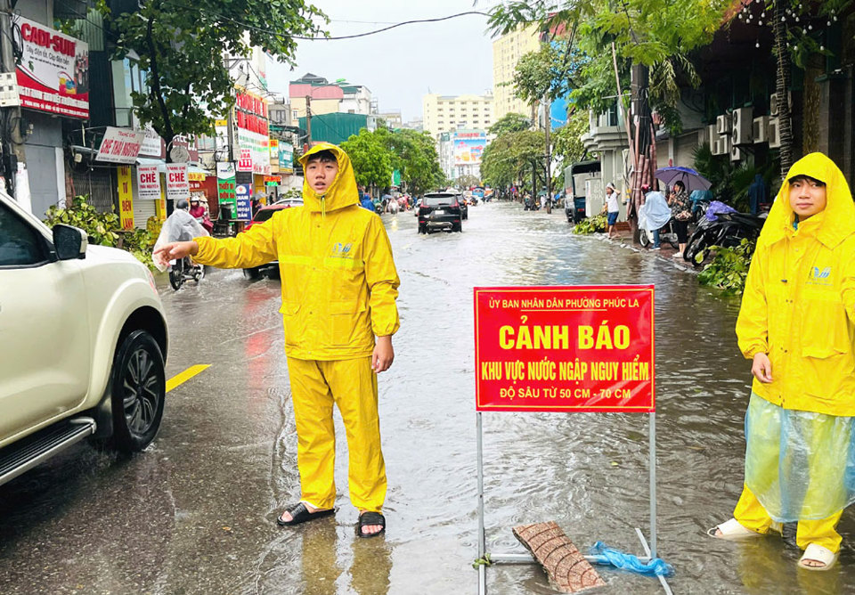 C&aacute;c lực lượng tăng cường trực, hướng dẫn cho người d&acirc;n hạn chế đi v&agrave;o tuyến đường ngập nặng.