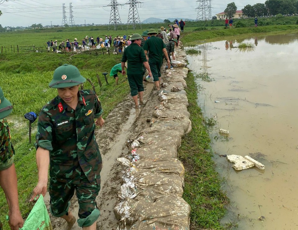 Lực lượng chức năng c&ugrave;ng Nh&acirc;n d&acirc;n c&aacute;c địa phương ven s&ocirc;ng Cầu gia cố ch&acirc;n đ&ecirc;, xử l&yacute; chống tr&agrave;n.