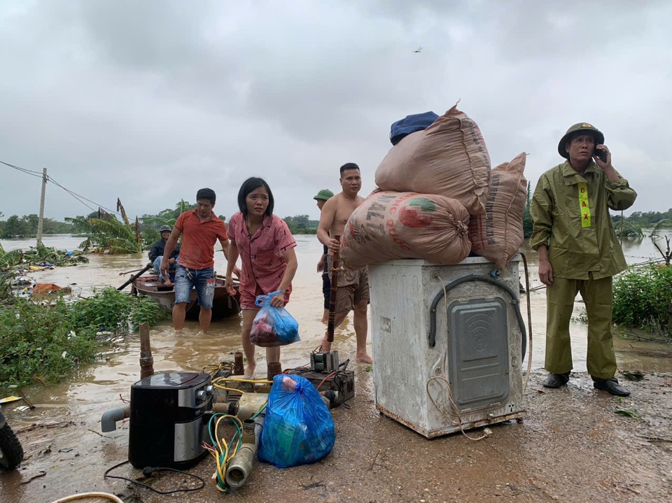 Lực lượng chức năng t&iacute;ch cực hỗ trợ người d&acirc;n vận chuyển cả đồ đạc đến nơi an to&agrave;n. Ảnh: V.B.