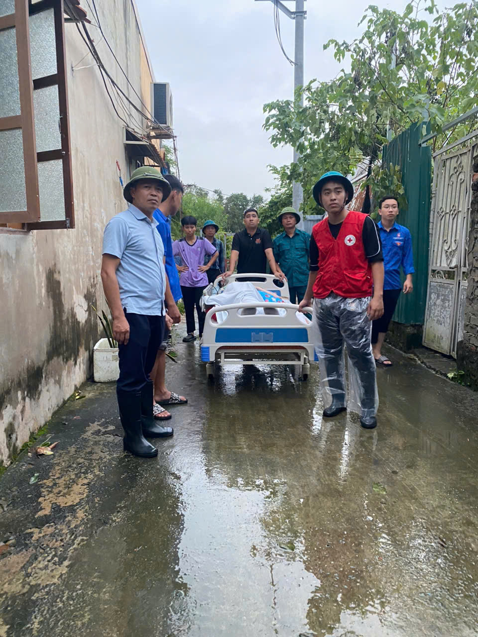 Thanh ni&ecirc;n xung k&iacute;ch hỗ trợ di chuyển người d&acirc;n nằm liệt giường l&acirc;u năm ở ngo&agrave;i đ&ecirc; s&ocirc;ng Hồng về nơi an to&agrave;n.