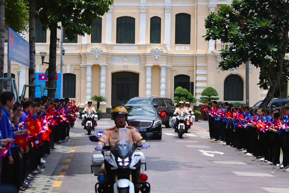 Đo&agrave;n xe hộ tống Tổng B&iacute; thư, Chủ tịch nước L&agrave;o Thongloun Sisoulith đến Kh&aacute;ch sạn REX (quận 1), trong sự đ&oacute;n ch&agrave;o của thanh ni&ecirc;n TP Hồ Ch&iacute; Minh