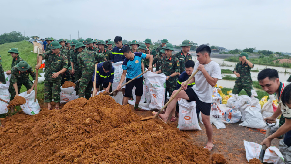 Qu&acirc;n d&acirc;n đồng l&ograve;ng hộ đ&ecirc; chống lũ.