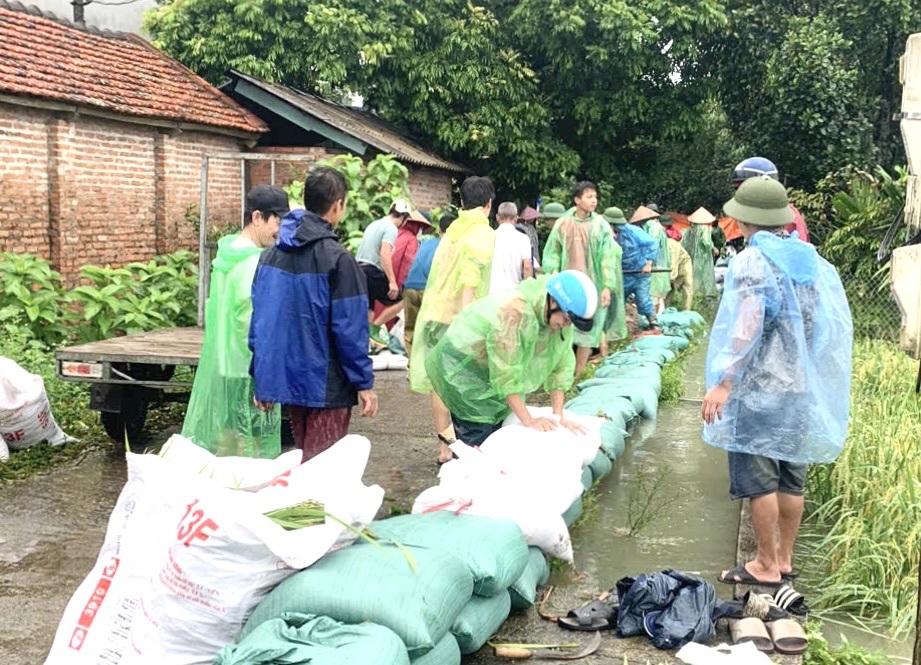 Người d&acirc;n tham gia đắp bao đất chống ngập lụt.