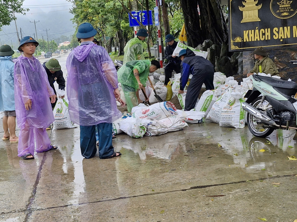 Chính quy&ecirc;̀n và Nh&acirc;n d&acirc;n xã Hương Sơn đắp đ&ecirc; bao cát ngăn lũ. Ảnh: Văn Bi&ecirc;n