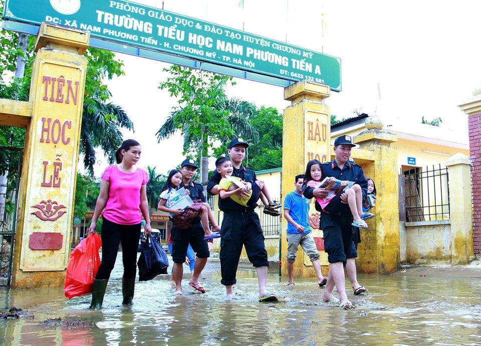 C&ocirc;ng an H&agrave; Nội hỗ trợ người d&acirc;n x&atilde; Nam Phương Tiến, huyện Chương Mỹ, trong những ng&agrave;y mưa b&atilde;o g&acirc;y ngập. Ảnh: Phạm H&ugrave;ng