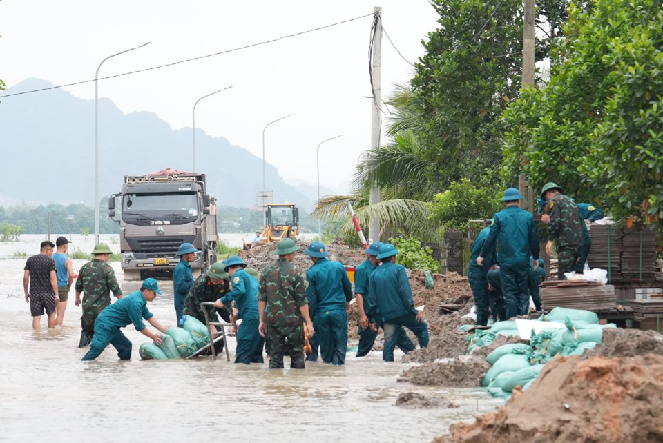 Lực lượng chức năng huyện Ứng H&ograve;a nỗ lực ph&ograve;ng, chống lụt b&atilde;o. Ảnh: Lại Tấn