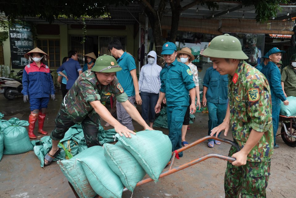 Lực lượng c&ocirc;ng an, qu&acirc;n sự, d&acirc;n quận tự vệ huyện Ứng H&ograve;a gia cố điểm xung yếu do ngập tr&agrave;n. Ảnh: Lại Tấn