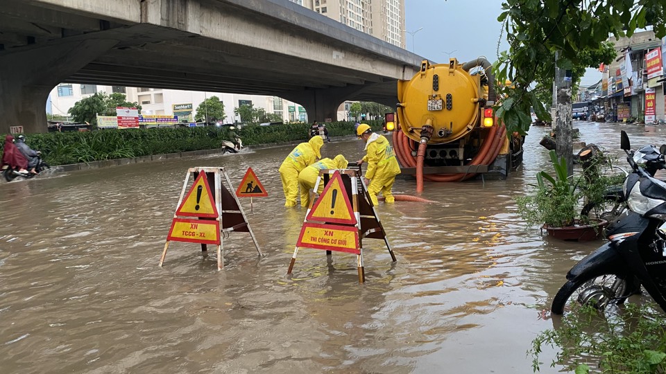 C&ocirc;ng nh&acirc;n tho&aacute;t nước l&agrave;m nhiệm vụ tr&ecirc;n phố Nguyễn Xiển.