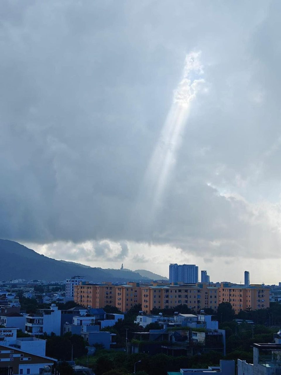 Ch&ugrave;m tia nắng chiếu thẳng xuống giữa bầu trời m&acirc;y đen giăng k&iacute;n tựa như một cảnh phim.