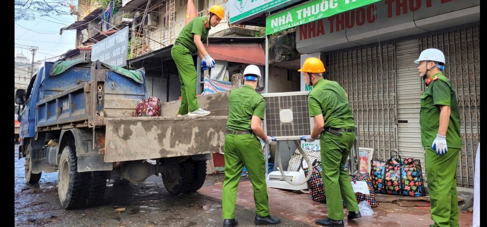 Lực lượng chức năng hỗ trợ người d&acirc;n di dời. Ảnh: Tiến Bảo