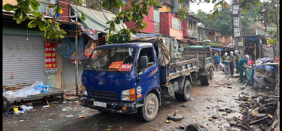 Lực lượng chức năng hỗ trợ người d&acirc;n di dời khỏi chung cư cũ. Ảnh: Tiến Bảo