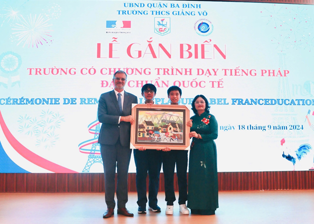 C&ocirc; gi&aacute;o T&ocirc; Thị Hải Yến - B&iacute; thư Chi bộ, Hiệu trưởng nh&agrave; trường c&ugrave;ng c&aacute;c bạn học sinh tặng qu&agrave; ng&agrave;i Đại sứ Olivier Brochet.