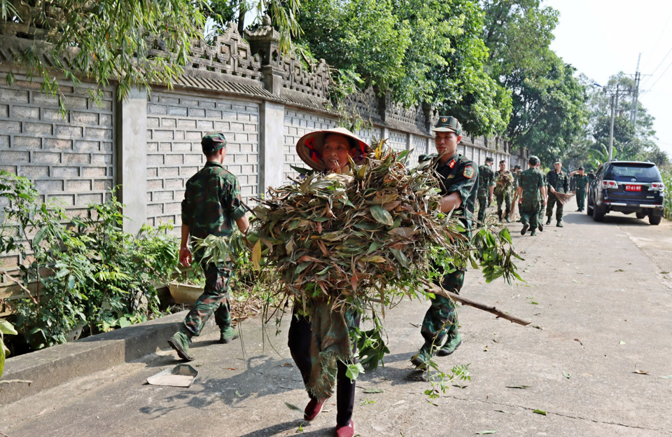 Qu&acirc;n v&agrave; d&acirc;n thị x&atilde; Sơn T&acirc;y chung tay khắc phục hậu quả mưa lũ. Ảnh: Hồng Qu&yacute;