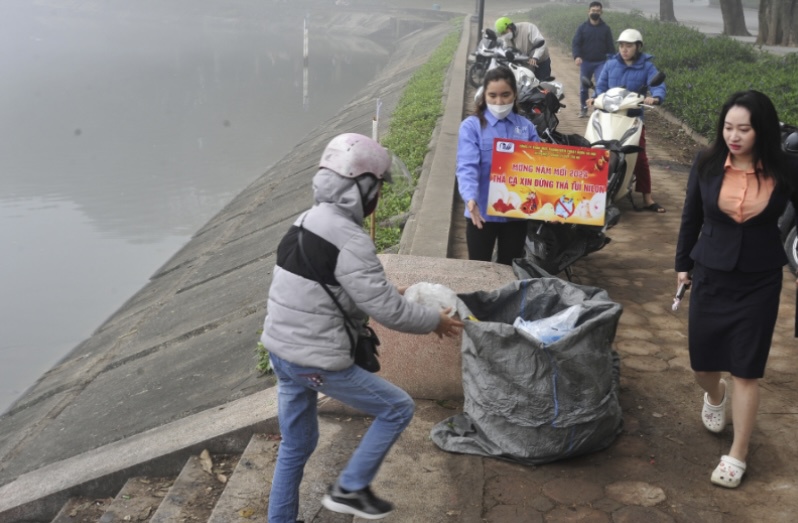 Người d&acirc;n sau khi thả c&aacute; ph&oacute;ng sinh đ&atilde; bỏ t&uacute;i ni l&ocirc;ng v&agrave;o đ&uacute;ng nơi quy định.