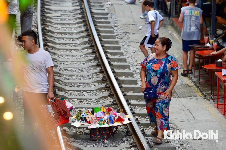 Sau khi t&agrave;u đi qua, người d&acirc;n v&agrave; du kh&aacute;ch lại xuống giữa đường ray t&agrave;u b&aacute;n h&agrave;ng v&agrave; chụp ảnh.