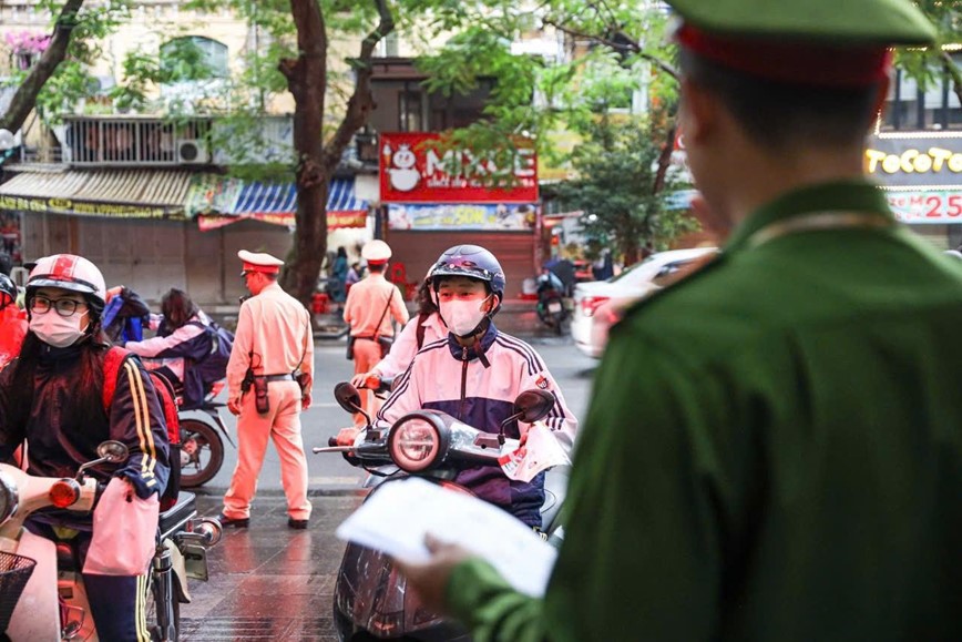 Tổ c&ocirc;ng t&aacute;c tăng cường kiểm tra, phối hợp ph&aacute;t tờ rơi hướng dẫn ATGT cho học sinh ngay tại cổng trường.