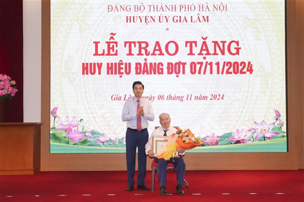 B&iacute; thư Huyện ủy Gia L&acirc;m Nguyễn Việt H&agrave; trao Huy hiệu 70 năm tuổi Đảng cho đảng vi&ecirc;n l&atilde;o th&agrave;nh Nguyễn Văn H&ograve;a.