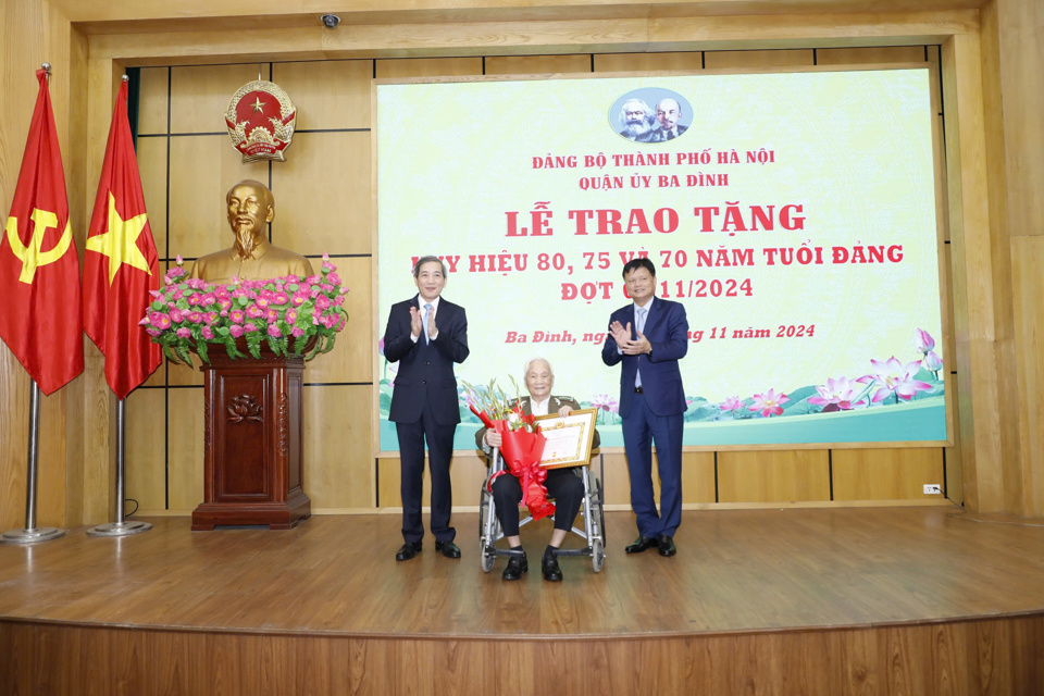 Trưởng ban Tổ chức Th&agrave;nh ủy Vũ Đức Bảo (b&ecirc;n phải) v&agrave; B&iacute; thư Quận ủy Ba Đ&igrave;nh Ho&agrave;ng Minh Dũng Tiến (b&ecirc;n tr&aacute;i) trao Huy hiệu 80 năm tuổi Đảng tặng đảng vi&ecirc;n l&atilde;o th&agrave;nh.