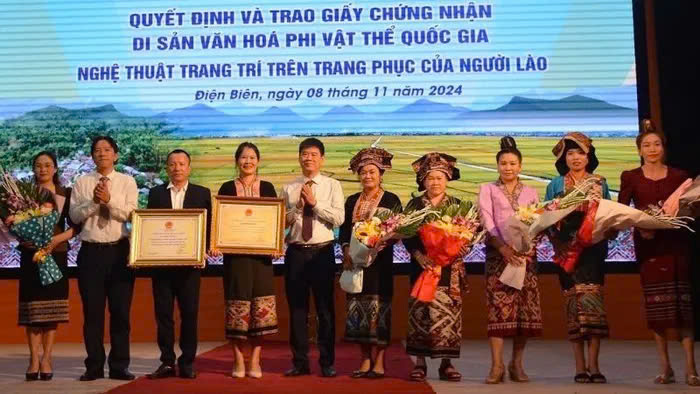 Đồng ch&iacute; Nguyễn Th&aacute;i B&igrave;nh, Chủ tịch UBND huyện Điện Bi&ecirc;n v&agrave; đại diện l&atilde;nh đạo Sở Văn h&oacute;a - Thể thao v&agrave; Du lịch Điện Bi&ecirc;n trao Bằng c&ocirc;ng nhận Di sản văn h&oacute;a phi vật thể quốc gia Nghệ thuật trang tr&iacute; tr&ecirc;n trang phục của người L&agrave;o, cho cộng đồng d&acirc;n tộc L&agrave;o ở hai huyện Điện Bi&ecirc;n v&agrave; Điện Bi&ecirc;n Đ&ocirc;ng.