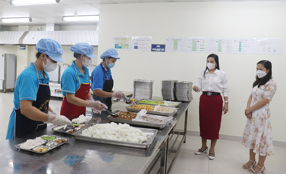 C&ocirc; gi&aacute;o Ho&agrave;ng Thị Tố Oanh &ndash; Ph&oacute; Hiệu trưởng Trường THCS Nguyễn Thị Minh Khai c&ugrave;ng đại diện cha mẹ học sinh gi&aacute;m s&aacute;t nh&acirc;n vi&ecirc;n bếp ăn chia suất ăn cho học sinh.