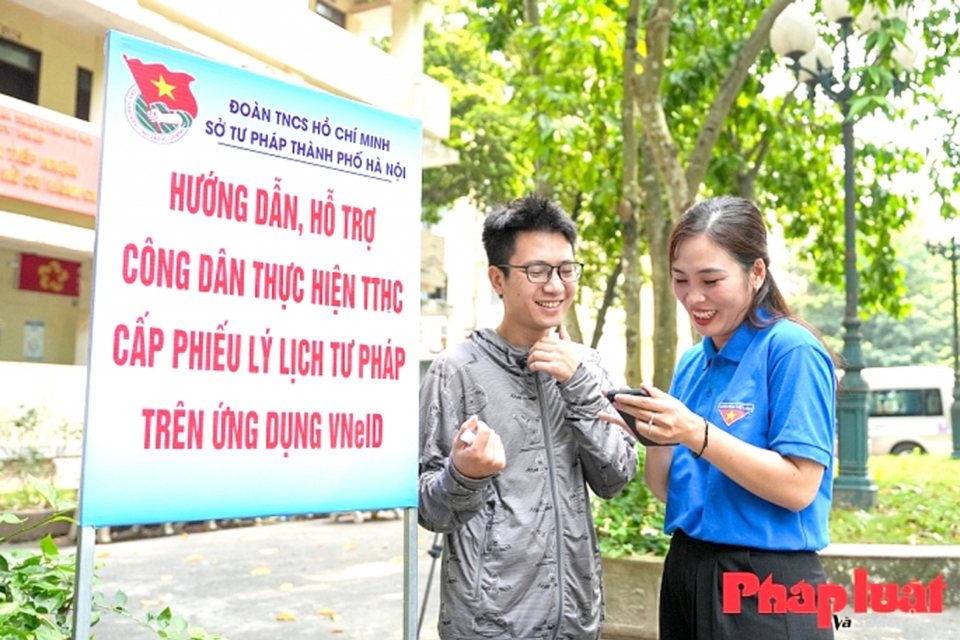 Ảnh 2: Đoàn Thanh niên Sở Tư pháp thành phố Hà Nội nhiệt tình hướng dẫn công dân thực hiện cấp Phiếu Lý lịch tư pháp trên ứng dụng VneID. Ảnh: Khánh Huy  