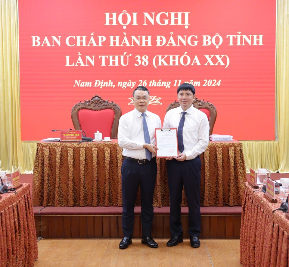 B&iacute; thư Tỉnh ủy Nam Định Đặng Kh&aacute;nh To&agrave;n (b&ecirc;n tr&aacute;i) trao quyết định của Ban B&iacute; thư Trung ương Đảng tới &ocirc;ng Nguyễn Ho&agrave;ng Anh. Ảnh: Duy Hưng