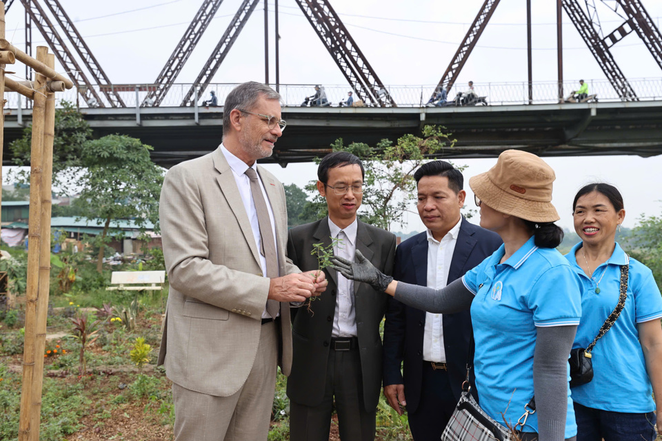 Đại sứ Ph&aacute;p trao đổi với người d&acirc;n khu vực về khu vui chơi dưới ch&acirc;n cầu Long Bi&ecirc;n v&agrave; c&aacute;c loại thực vật, thảo dược trồng l&acirc;n cận. Ảnh: Kh&aacute;nh Huy