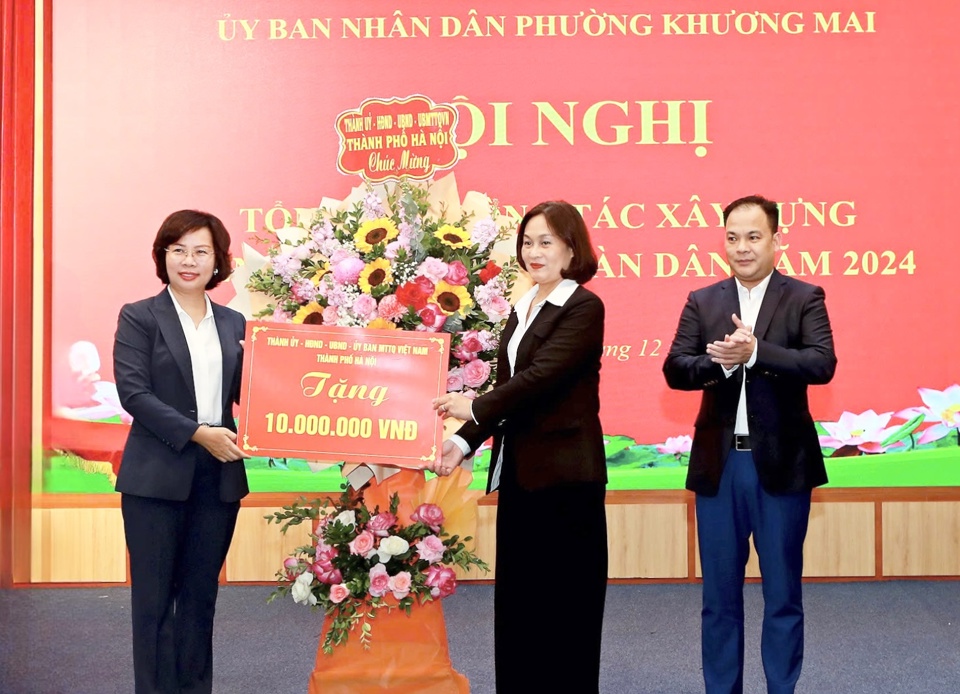 Thay mặt lãnh đạo TP Hà Nội, Ủy viên Ban Thường vụ Thành ủy, Bí thư Quận ủy Thanh Xuân Bùi Huyền Mai tặng hoa của Thành ủy - HĐND - UBND - Ủy ban MTTQ Việt Nam TP Hà Nội  chúc mừng Hội nghị Tổng kết công tác xây dựng nền quốc phòng toàn dân tại phường Khương Mai, chiều 6/12