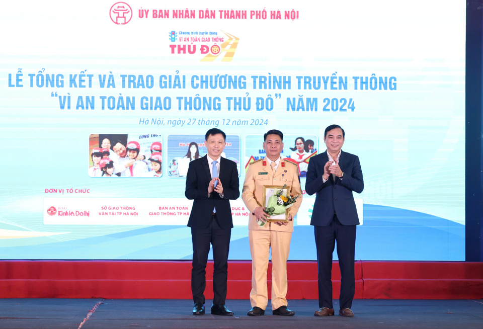 PGS.TS Nguyễn Th&agrave;nh Lợi - Tổng Bi&ecirc;n tập B&aacute;o Kinh tế &amp; Đ&ocirc; thị v&agrave; Ph&oacute; Gi&aacute;m đốc Sở GTVT H&agrave; Nội Đ&agrave;o Duy Phong trao giải Nhất cuộc thi viết ''V&igrave; an to&agrave;n giao th&ocirc;ng Thủ đ&ocirc;'' năm 2024 cho&nbsp;trung t&aacute; Nguyễn Ngọc Tiến (Đội tuy&ecirc;n truyền điều tra giải quyết tai nạn giao th&ocirc;ng v&agrave; xử l&yacute; vi phạm, Ph&ograve;ng CSGT, C&ocirc;ng an TP H&agrave; Nội).