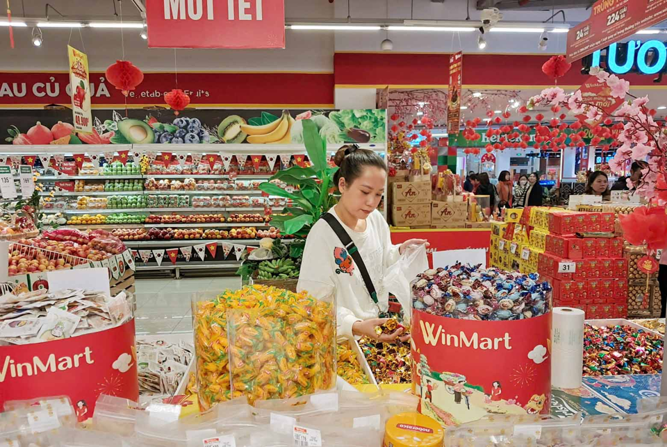 Người ti&ecirc;u d&ugrave;ng mua b&aacute;nh kẹo Tết giảm gi&aacute; tại si&ecirc;u thị Winmart. Ảnh: Ho&agrave;i Nam