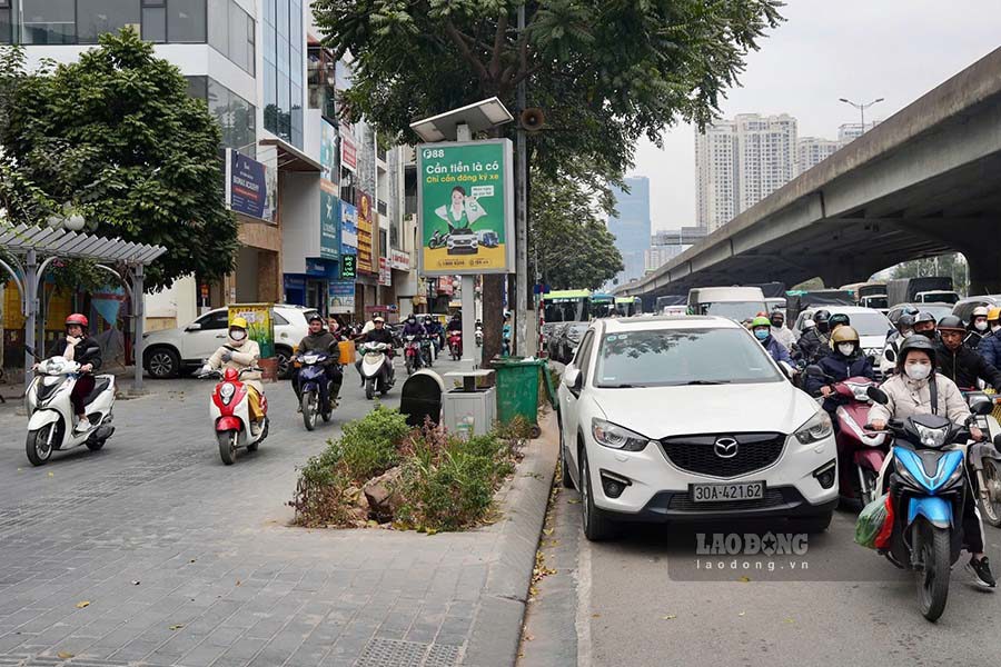 Đường Khuất Duy Tiến &ugrave;n tắc, người d&acirc;n đi xe m&aacute;y đ&atilde; leo l&ecirc;n vỉa h&egrave; để đi. H&igrave;nh ảnh ghi nhận đầu giờ chiều nay (11/1).