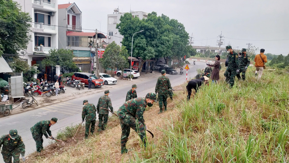 C&aacute;c chiến sĩ bộ đội c&ugrave;ng người d&acirc;n tham gia vệ sinh m&ocirc;i trường, x&acirc;y dựng tuyến đ&ecirc; kiểu mẫu.