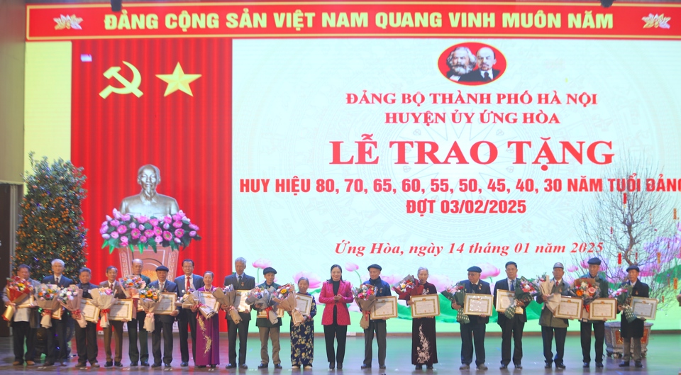 B&iacute; thư Huyện uỷ Ứng Ho&agrave; B&ugrave;i Thị Thu Hiền trao Huy hiệu Đảng cho c&aacute;c đảng vi&ecirc;n. Ảnh: Lại Tấn