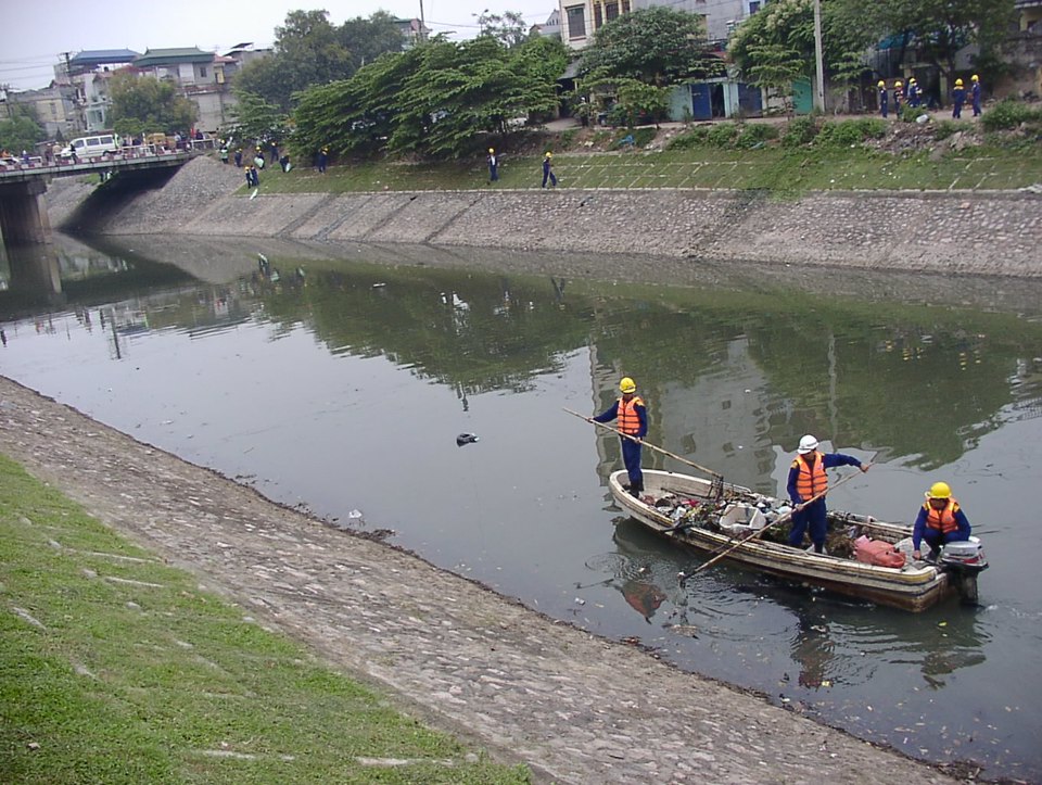 Công nhân vệ sinh mô trường vớt rác gây ô nhiễm trên sông Tô Lịch. Ảnh: Hải Linh