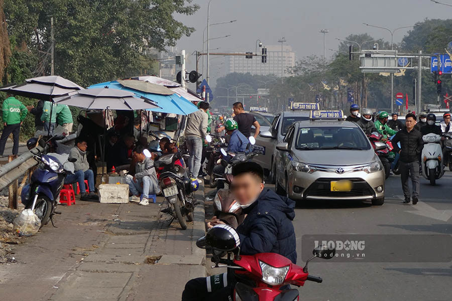 H&agrave;ng qu&aacute;n chiếm trọn vỉa h&egrave;, dưới l&ograve;ng đường th&igrave; xe taxi, xe &ocirc;m dừng đỗ đ&oacute;n trả kh&aacute;ch.