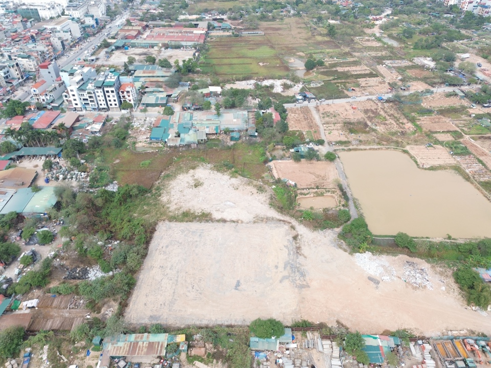 Ngay s&aacute;t b&atilde;i tập kết, m&aacute;y m&oacute;c, thiết bị v&agrave; vật liệu x&acirc;y dựng l&agrave; một b&atilde;i đất rộng đ&atilde; bị san lấp mặt bằng, lu l&egrave;n bằng phẳng. Ảnh: Nguyễn Qu&yacute;