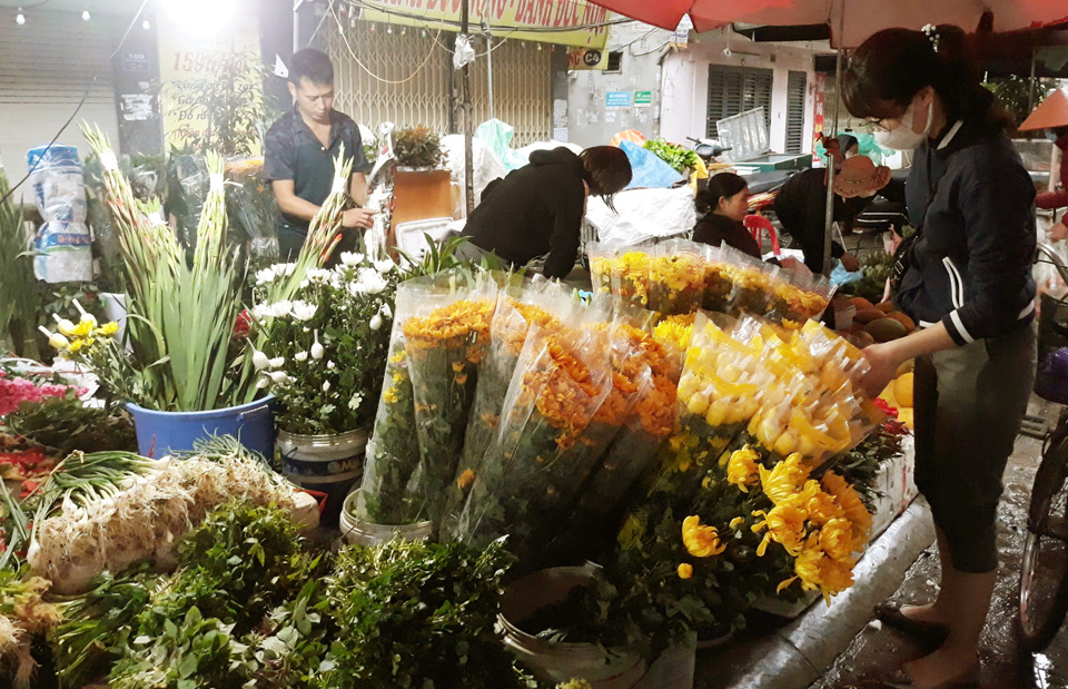 Người ti&ecirc;u d&ugrave;ng mua hoa tươi dịp Rằm th&aacute;ng Gi&ecirc;ng tại chợ truyền thống. Ảnh: Ho&agrave;i Na