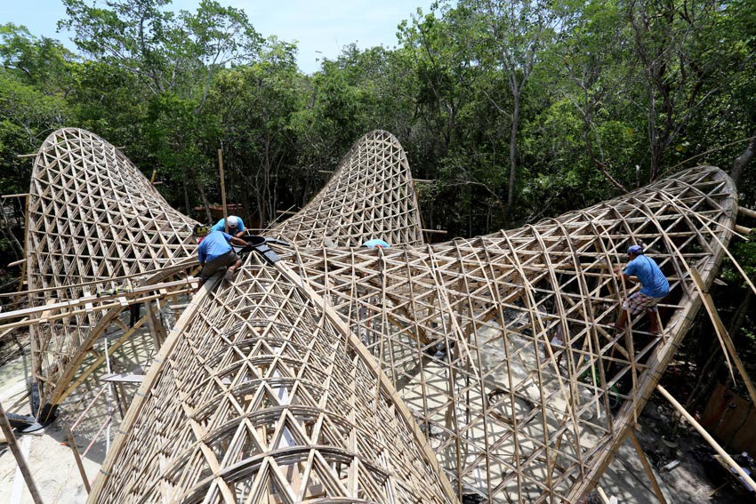 Những v&ograve;m cong kh&ocirc;ng đứng độc lập m&agrave; n&acirc;ng đỡ lẫn nhau, giống như c&aacute;ch con người c&ugrave;ng nhau tạo n&ecirc;n cộng đồng. Mỗi thanh tre được uốn ngay tại c&ocirc;ng trường, gắn kết bằng v&iacute;t v&agrave; d&acirc;y đai, đan xen v&agrave;o nhau để tạo th&agrave;nh một hệ thống vững chắc.