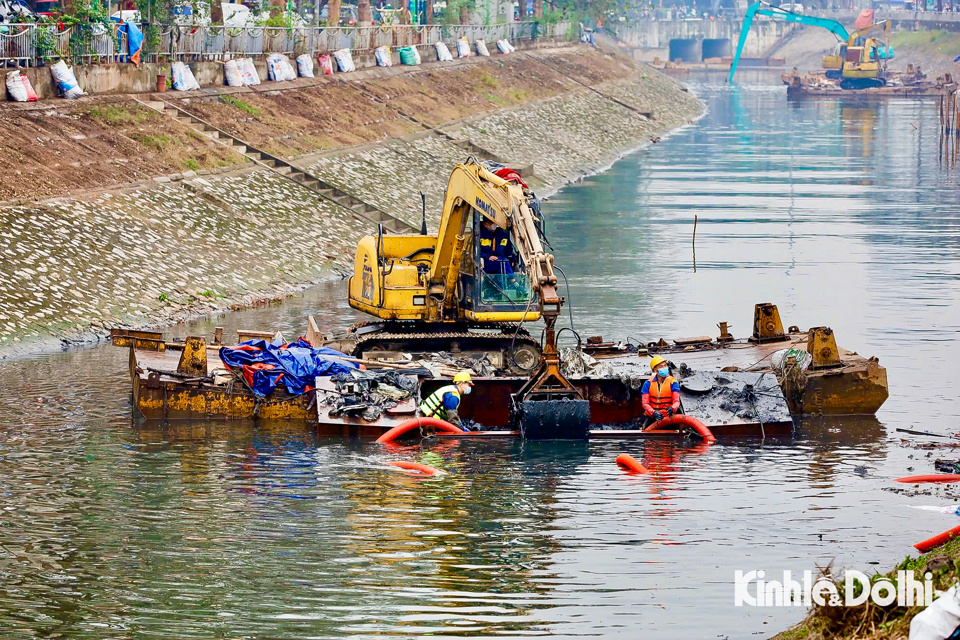 Ngay từ s&aacute;ng sớm, c&aacute;c c&ocirc;ng nh&acirc;n bắt đầu dầm m&igrave;nh xuống l&ograve;ng s&ocirc;ng, d&ugrave;ng dụng cụ chuy&ecirc;n dụng nạo v&eacute;t những mảng b&ugrave;n đen kịt, đặc qu&aacute;nh...