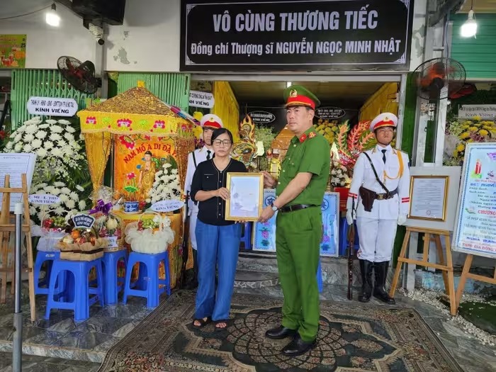 Đại diện C&ocirc;ng an tỉnh B&agrave; Rịa - Vũng T&agrave;u trao quyết định truy thăng cấp h&agrave;m cho th&acirc;n nh&acirc;n chiến sĩ Nguyễn Ngọc Minh Nhật. Ảnh: hanoimoi.vn