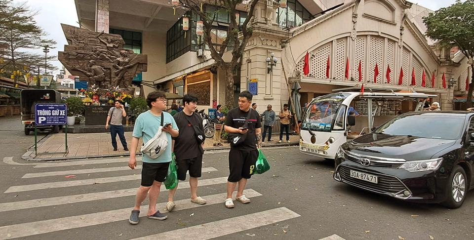 Kh&aacute;ch du lịch đợi xe trung chuyển từ điểm đ&oacute;n trước cổng chợ Đồng Xu&acirc;n di chuyển v&agrave;o kh&aacute;ch sạn trong phố cổ. Ảnh: Ho&agrave;i Nam