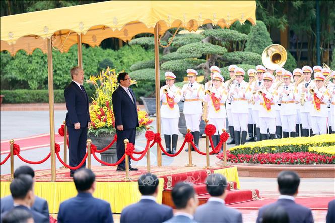 Thủ tướng Phạm Minh Ch&iacute;nh v&agrave; Thủ tướng Kyrgyzstan Adylbek Kasimalyev nghe qu&acirc;n nhạc cử Quốc thiều hai nước. Ảnh: TTXVN