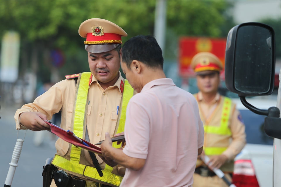 Cảnh s&aacute;t giao th&ocirc;ng kiểm tra, xử l&yacute; l&aacute;i xe vi phạm tr&ecirc;n đường Phạm Văn Đồng, quận Bắc Từ Li&ecirc;m. Ảnh Phạm H&ugrave;ng